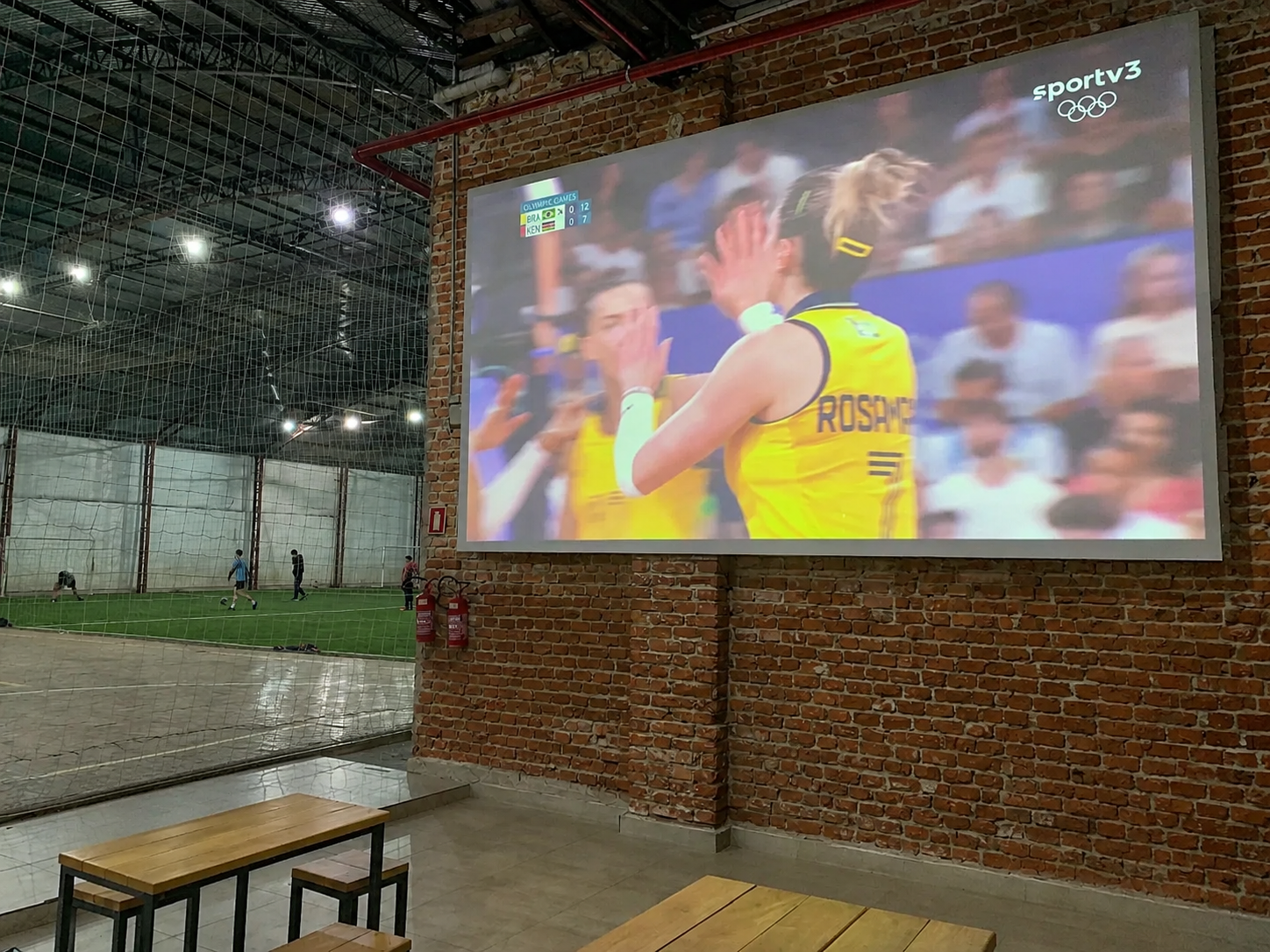 Área social com telão e vista para a quadra